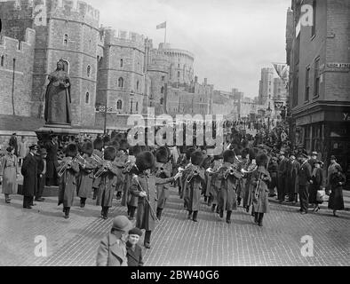 Now that the King and Queen have taken up residence at Windsor Castle a full guard is being mounted for the first time since King George V last days there. Photo shows: The band marching away from Windsor Castle after the guard change. 9 April 1937 Stock Photo