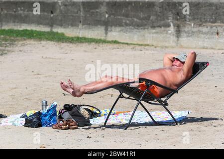 Troon, UK. 29th May, 2020. As the local temperatures rise to at least the mid 20's C, and with the relaxation of the covid 19 lockdown measures, people are once again returning to the beach. for pleasure while trying to maintain social distancing. Credit: Findlay/Alamy Live News Stock Photo