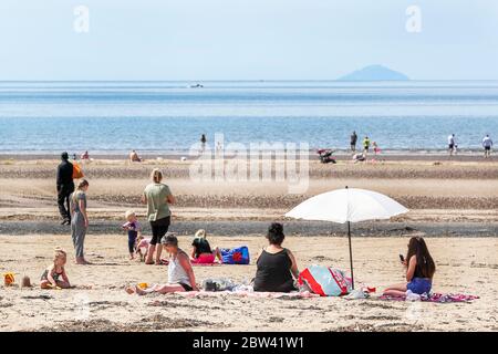 Troon, UK. 29th May, 2020. As the local temperatures rise to at least the mid 20's C, and with the relaxation of the covid 19 lockdown measures, people are once again returning to the beach. for pleasure while trying to maintain social distancing. Credit: Findlay/Alamy Live News Stock Photo