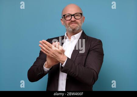 Handsome mature man with beard in suit applauding appproving your project. Stock Photo
