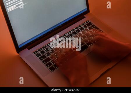 working late in the night, hands typing text on a laptop keyboard, motion blur effect Stock Photo