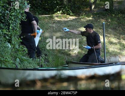 Police forensic officers gather evidence near the boats by the lake on the grounds of Lullingstone Castle in Eynsford, Kent, where a man has died after reports of a disturbance in the grounds on Thursday evening.