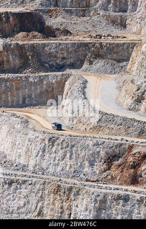 Industrial stone mining. Truck in the middle of huge quarry. Stock Photo