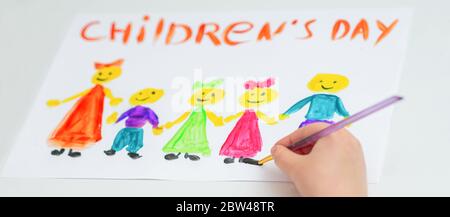 Girl is drawing the colorful children by watercolors with words Happy Children's Day. Stock Photo