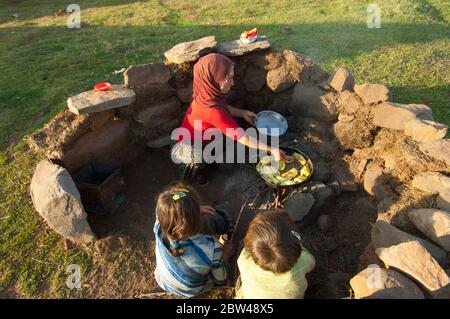 Asien, Türkei, Provinz Bingöl, Frau vom Stamm der Beritan-Nomaden an  Feuerstelle beim Zubereiten von Essen auf einer Hochweide in den Serafettin-Berg Stock Photo