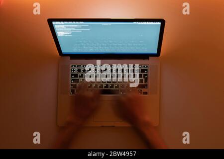 working late in the night, hands typing text on a laptop keyboard, motion blur effect Stock Photo