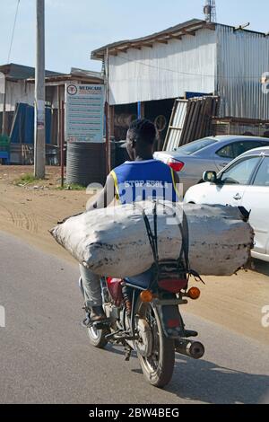 Young Sudanese transports a sack of charcoal on a motorcycle, the slogan 'Stop Ebola' can be read on his t-shirt, taken on 19.12.2019. Photo: Matthias Todt/dpa-Zentralbild/ZB/Picture Alliance | usage worldwide Stock Photo