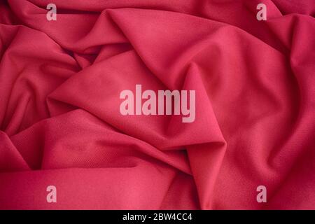 Red folded fabric texture background. Close up. Stock Photo