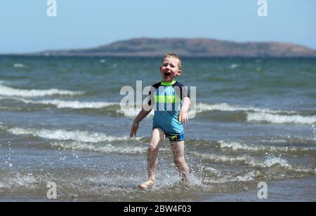 Four year old Cian Walshe plays in the sea off Portmarnock Beach, Dublin, as the warm weather continues. Picture date: Friday May 29, 2020. The dry sunny weather is set to continue over the June bank holiday weekend, with temperatures forecast to hit 25C in some areas. See PA story WEATHER Sun Ireland. Photo credit should read: Brian Lawless/PA Wire Stock Photo