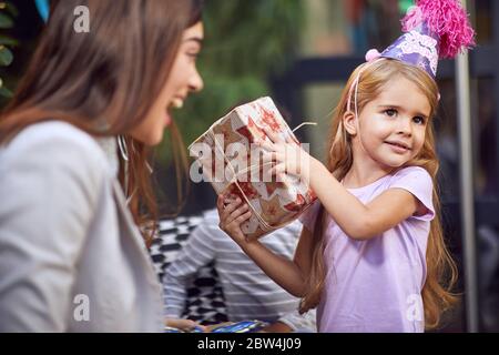 Birthday girl and her  presents.Happy  child girl opening birthday gift.Birthday party at home. Stock Photo