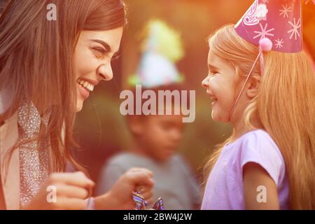 Smiling mother surprise her  happy  girl with birthday party. Stock Photo