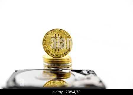 Stack of Gold bitcoin tokens on top of an open hard drive.Worldwide virtual internet cryptocurrency,digital payment system.Concept Digital coin money Stock Photo