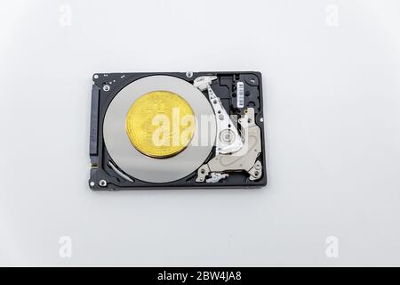 Gold bitcoin token on top of an open hard drive.Worldwide virtual internet cryptocurrency and digital payment system.Digital coin money crypto currenc Stock Photo