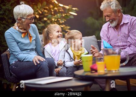Cheerful kids spending good and funny time with their  happy grandparents. Stock Photo