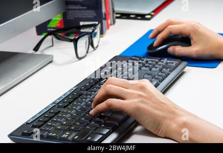 two hands typing on keyboard Stock Photo