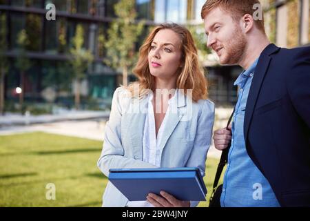 Male and female cowokers planning and discussing outside Stock Photo