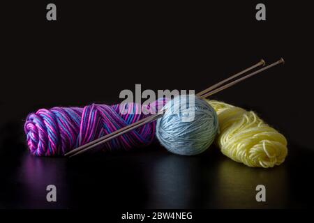 Colorful yarn with kitting needle on a black background Stock Photo