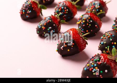 Chocolate fondue. Flat lay with strawberry in chocolate on pink background Stock Photo