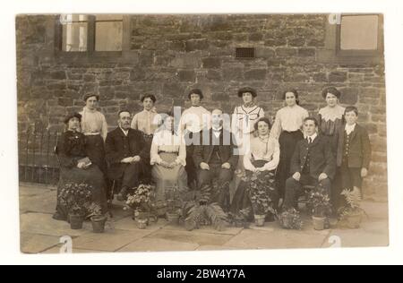Original early 1900's Edwardian postcard of smartly dressed Blackburn workers, maybe cotton mill office staff, posing outside their office building, with pots of flowers, posted 27 Sept 1904, Blackburn, Lancashire, England, U.K. Stock Photo