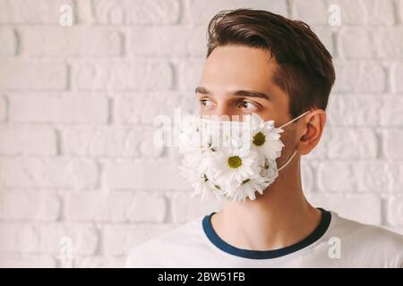 Young male doctor wearing summer medical face mask for personal protection against coronavirus and smiling. Happy man in protective face mask with dai Stock Photo