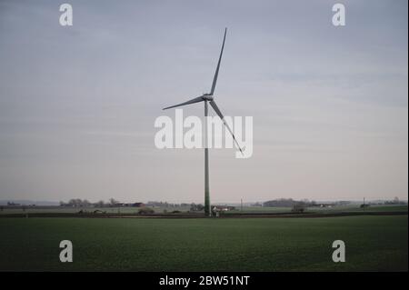 A single wind turbine stands tall above the flat farmlands of Skåne, Sweden Stock Photo