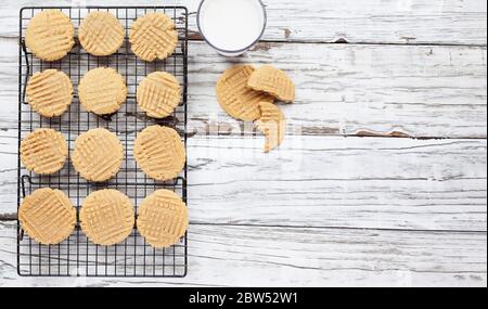 Top view of fresh baked, homemade peanut butter cookies and milk over a white rustic table. Flat lay with free space for text. Stock Photo