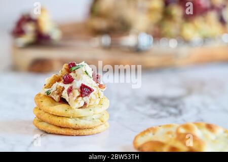 Fresh homemade cranberry cheese spread made with cream cheese, white cheddar, dried cranberries, walnuts, and chive over marble table. Selective focus Stock Photo