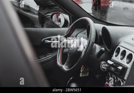 Modified interior of an Alfa Romeo 156. Improved black steering wheel with red stitiching, completely black interior. Stock Photo