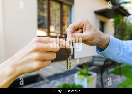 housing business - real estate agent giving new house keys to client Stock Photo
