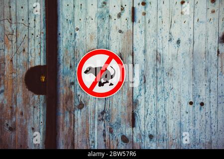No pooping sign on a wooden door. France Stock Photo