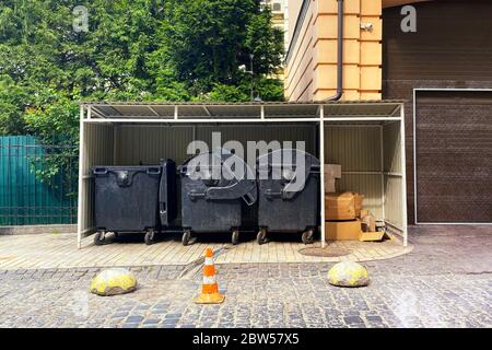 Dustbins being full with garbage. Garbage is pile lots dump. Garbage bins in sunny city. Cardboard is bundled into bales. Stock Photo