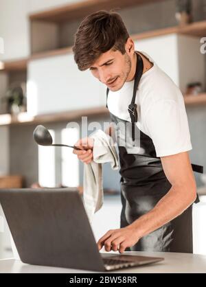 young man reading a recipe for soup in a laptop Stock Photo