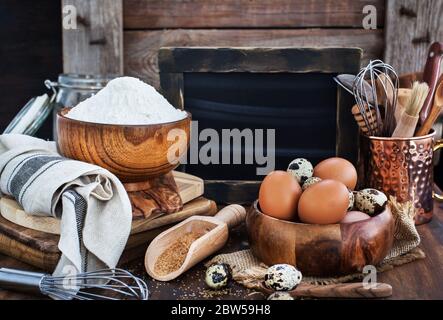 Baking ingredients and blackboard on background, wooden rustic style Stock Photo