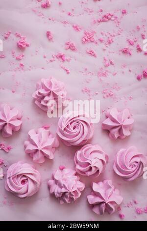 Pink meringues on plate, colorful background, top view Stock Photo