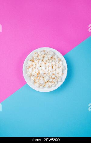White bowl of popcorn on a blue and purple background Stock Photo
