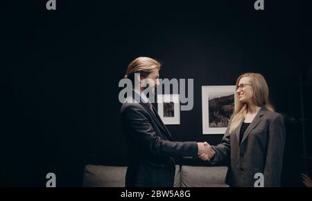 Business partners in formal outfit shaking hands at office Stock Photo