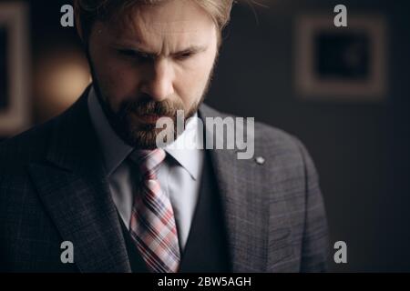 Thoughtful bearded man standing at modern office Stock Photo