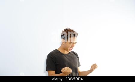 Young handsome Asian man over isolated background very happy and excited doing winner gesture with arms raised. Celebration concept. Stock Photo
