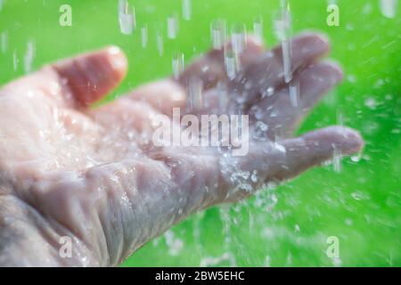 Water splashing on an outstretched hand. Stock Photo
