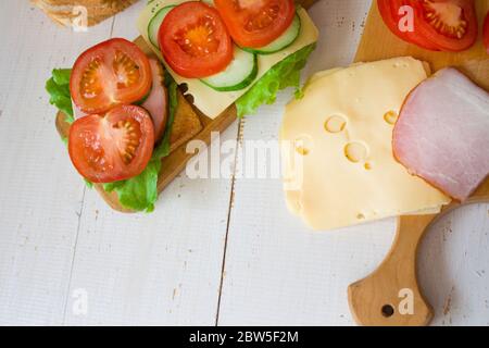 Cheese and ham toasts. Tomatoes and greens. Healthy eating concept. Banner. copyspace. Stock Photo