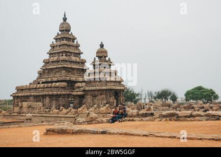 Tourists relax at Shore Temple — one of India's oldest structural Hindu temples in Mahabalipuram, Tamil Nadu Stock Photo