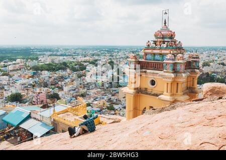 An Indian man takes a selfie next to Thayumanaswami Temple on top of Tiruchirappalli Rock Fort Stock Photo