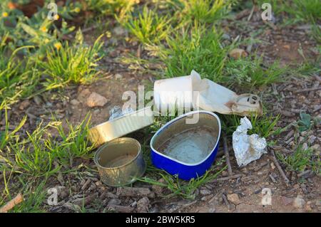 Close-up of some remains of garbage, such as tin cans, plastics, aluminum foil in the middle of nature Stock Photo