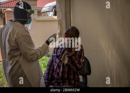 Elegu, Uganda. 28th May, 2020. A health worker dressed in a protective suit as a preventive measure collects swab samples from a truck driver to be tested for coronavirus at the Elegu border point. He will have to wait days for the result.Uganda closed its borders in March to everyone except cargo planes and truck drivers. Credit: SOPA Images Limited/Alamy Live News Stock Photo