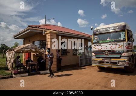 Elegu, Uganda. 28th May, 2020. A truck enters a checkpoint at the Elegu border point between Uganda and South Sudan. It currently takes one and a half weeks of a queue to get to this point.Uganda closed its borders in March to everyone except cargo planes and truck drivers. Credit: SOPA Images Limited/Alamy Live News Stock Photo