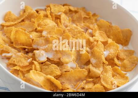 Bowl with traditional cornflakes and milk close up isolated on white background Stock Photo