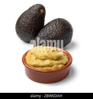 Bowl homemade guacamole with avocado in the background isolated on white background Stock Photo