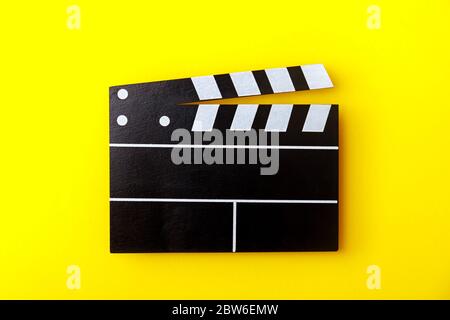 Cinema black clapperboard on yellow background. Modern cinematography, filmmaking. Stock Photo