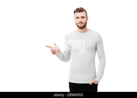 Young handsome bearded man pointing to the left with forefinger isolated Stock Photo