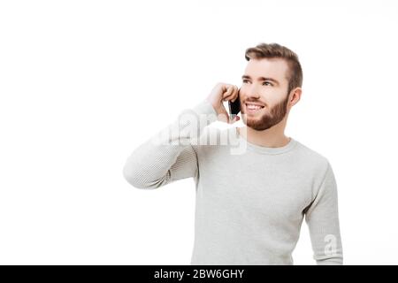 Handsome happy man talking on the phone smiling and looking up isolated Stock Photo